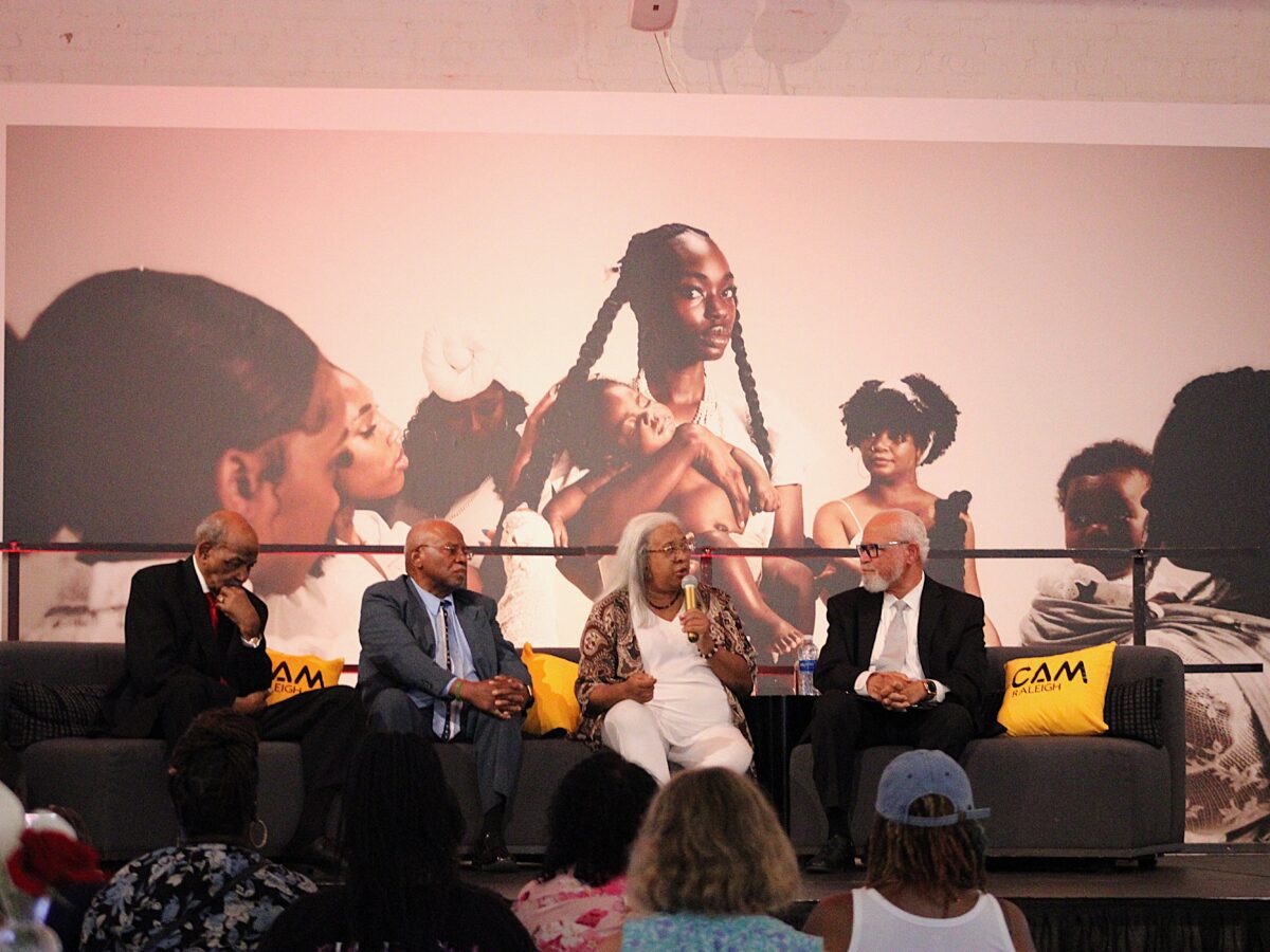 four people sitting on couches with a microphone