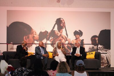 four people sitting on couches with a microphone