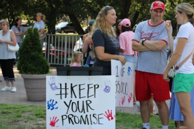 protesters holding keep your promise signs