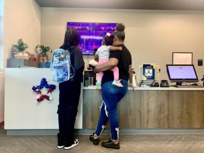 woman standing at desk with son and small daughter