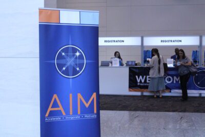 Big sign that says aim with a registration stand.