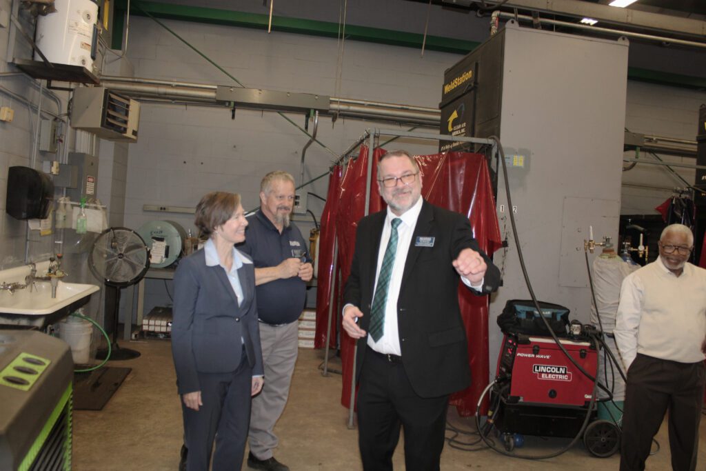 people standing in front of welding equipment