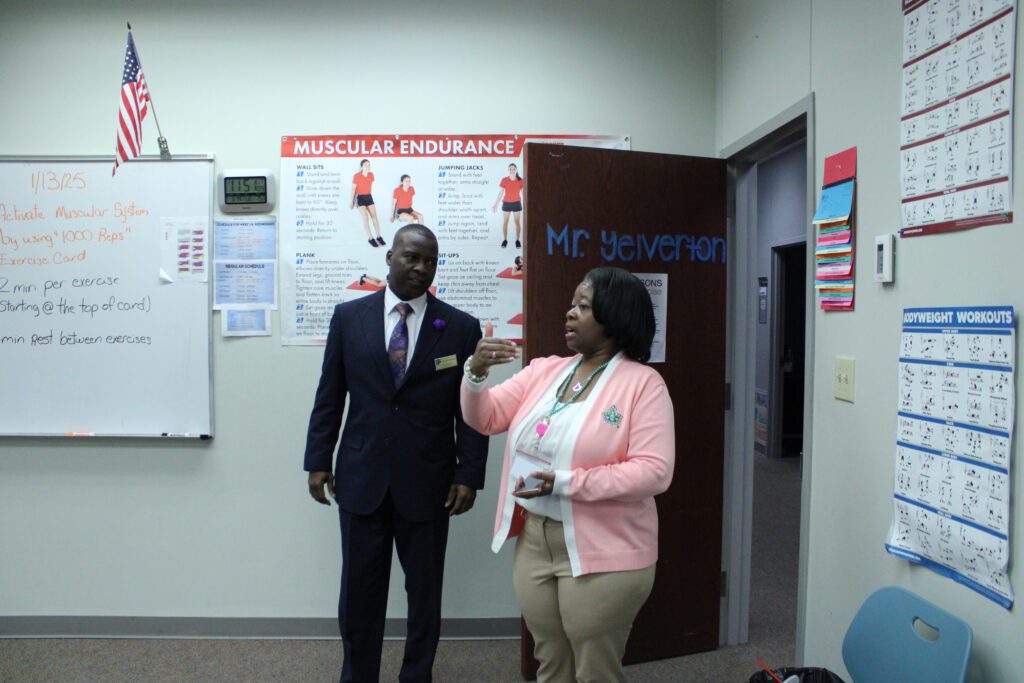 woman speaking with man in front of work out graphics